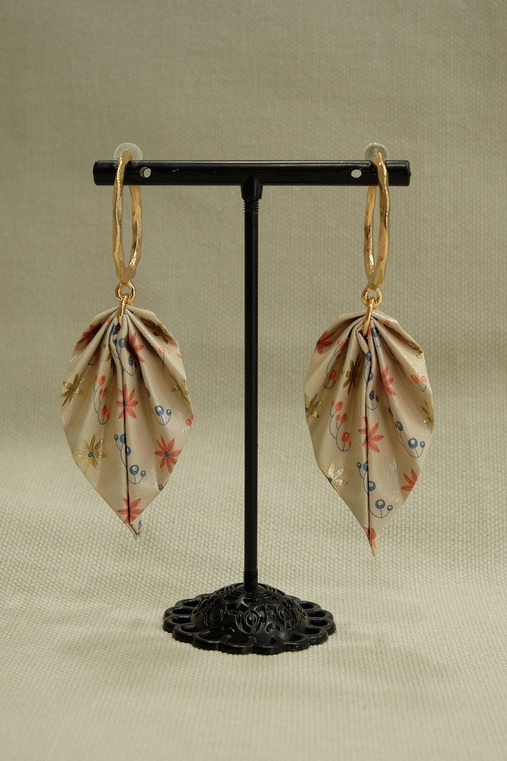 Boucle d'oreilles en origami en forme de feuille, de couleur beige avec des motifs