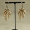 Boucle d'oreilles en origami en forme de feuille, de couleur beige avec des motifs couleur or