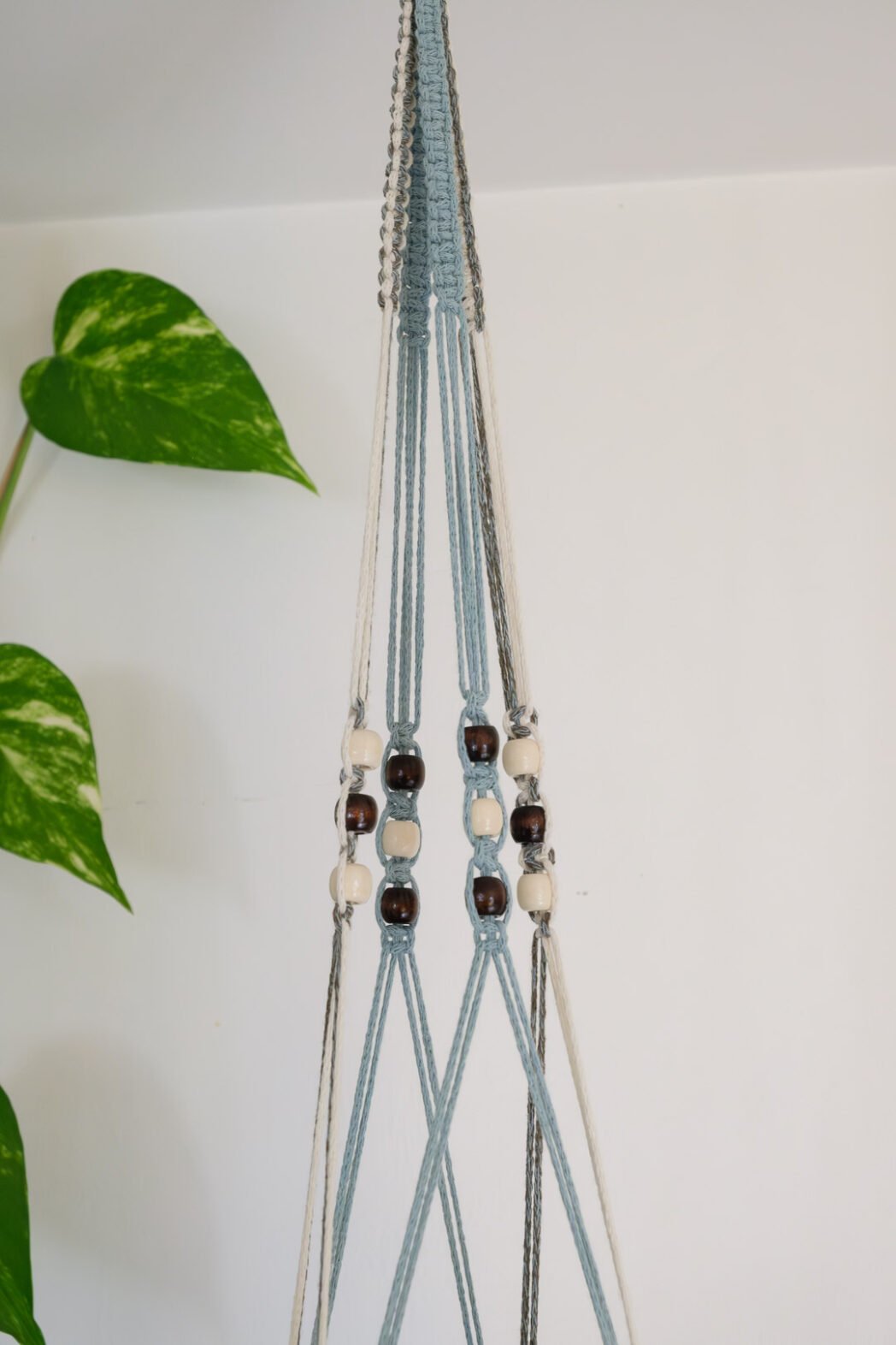 Suspension pour plantes en macramé, de couleur bleu, beige et vert